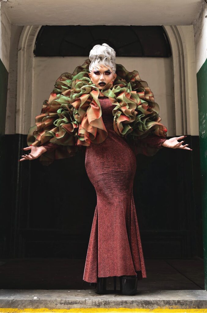Elegant woman in bold, artistic costume posing indoors with dramatic flair.