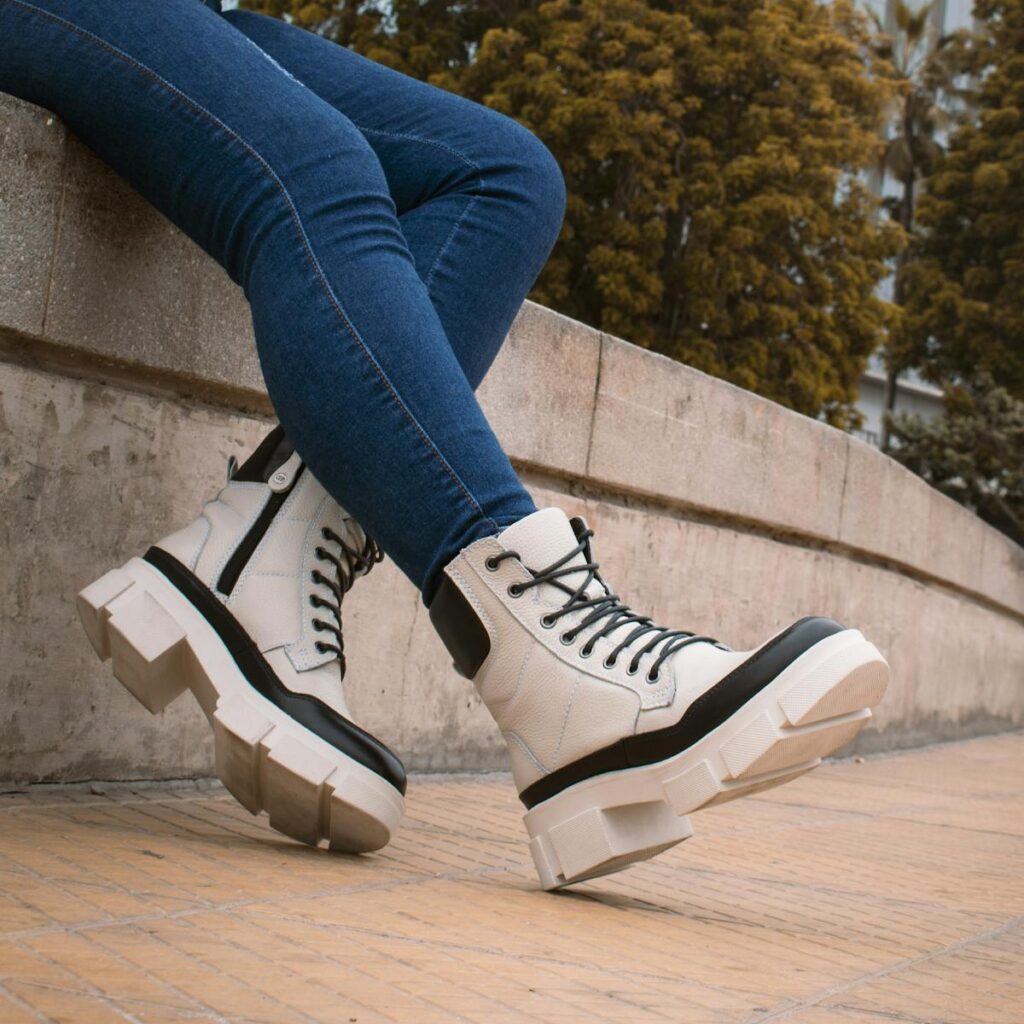 Stylish white platform boots paired with jeans outdoors, symbolizing urban fashion.