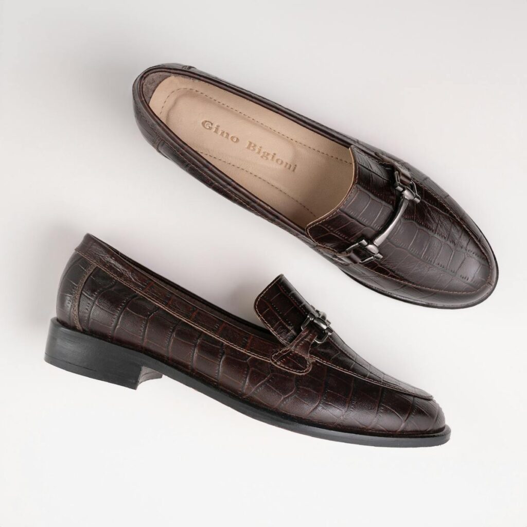 Stylish brown leather loafers with croc-embossed pattern on a white background.