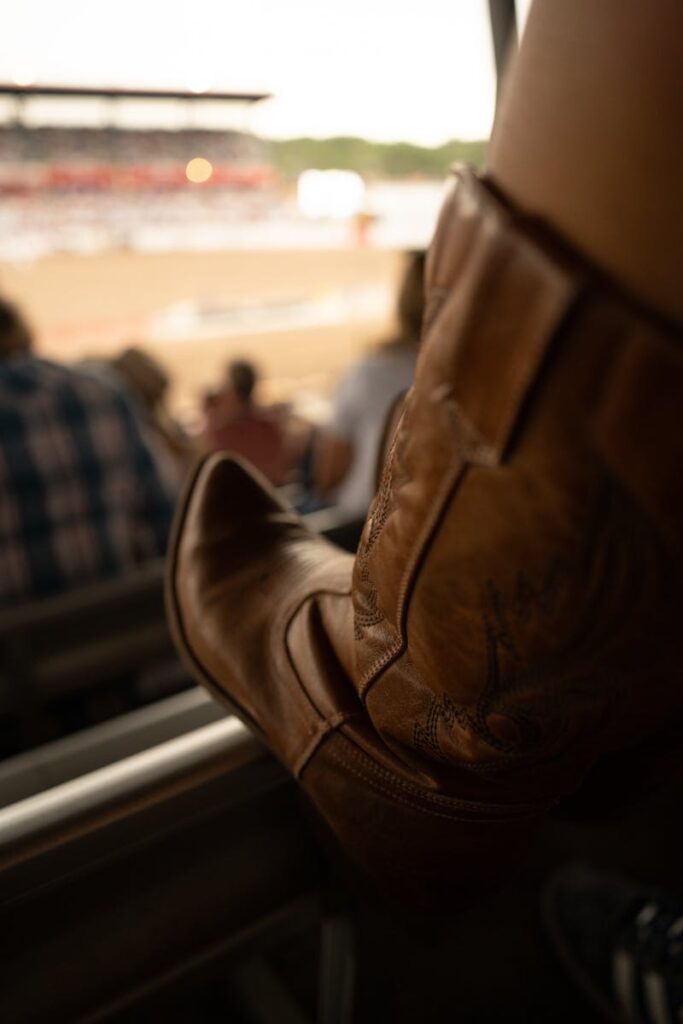 Stylish cowboy boots captured at a lively rodeo event, highlighting Western fashion and culture.