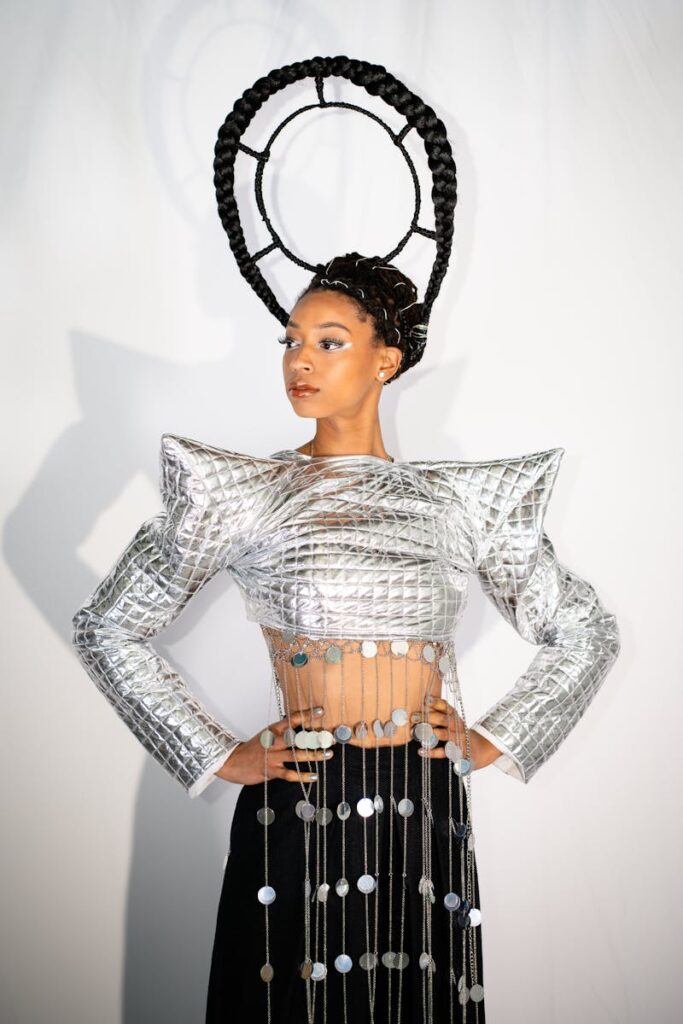 Capture of a model in avant-garde fashion with metallic attire and unique hairstyle.