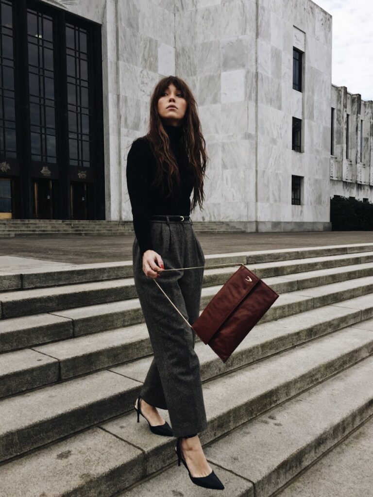 Fashion model showcasing chic attire on the steps of Salem's iconic building.