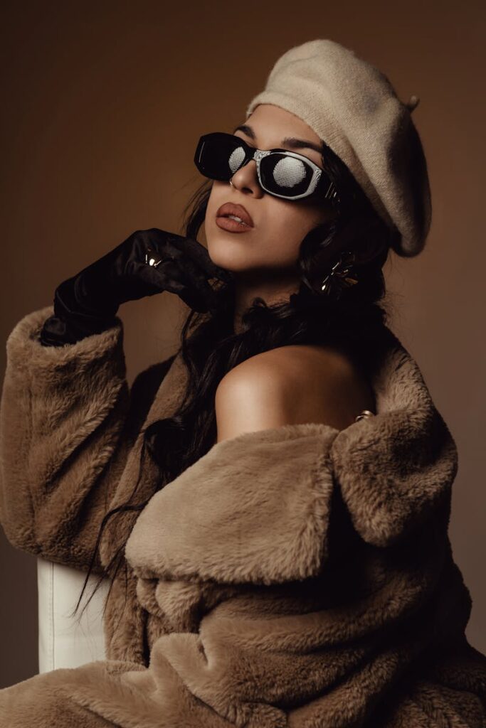 Stylish woman in fur coat and beret, exuding vintage elegance with dark sunglasses.
