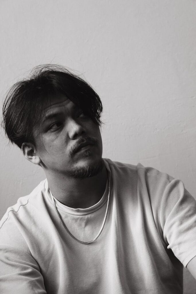 Thoughtful black and white portrait of a man looking upwards.