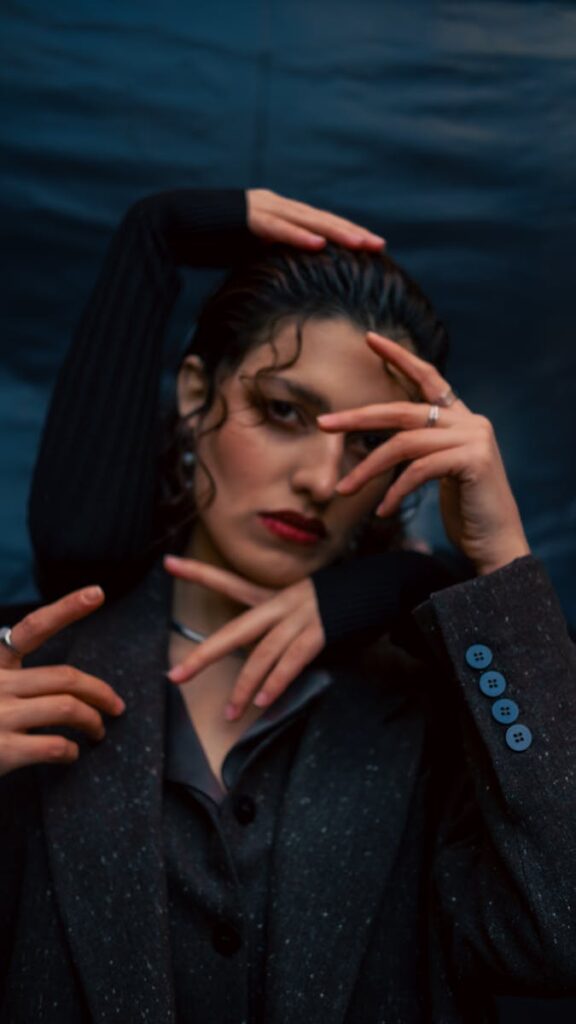 Unique portrait featuring creative hand placements with deep mood lighting.