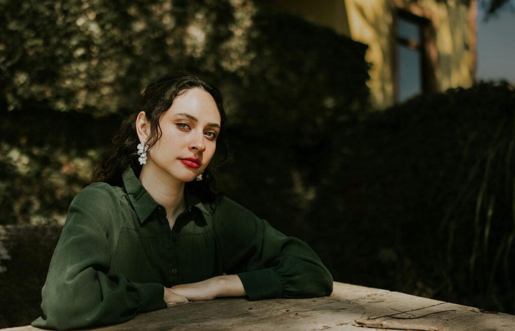 Portrait of a young woman in green dress outdoors, showcasing elegance and style.