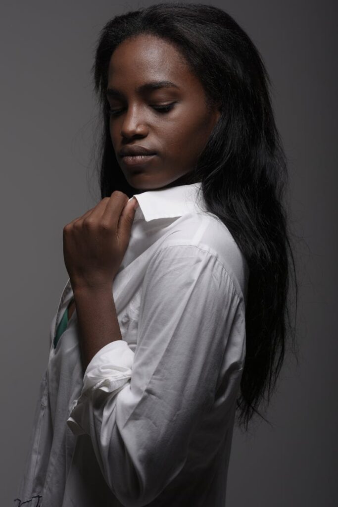 Elegant studio portrait of a woman in a white shirt, exuding confidence.