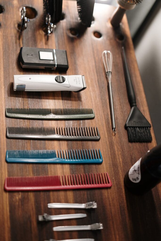 A collection of essential hairdressing tools organized on a wooden table for professional use.