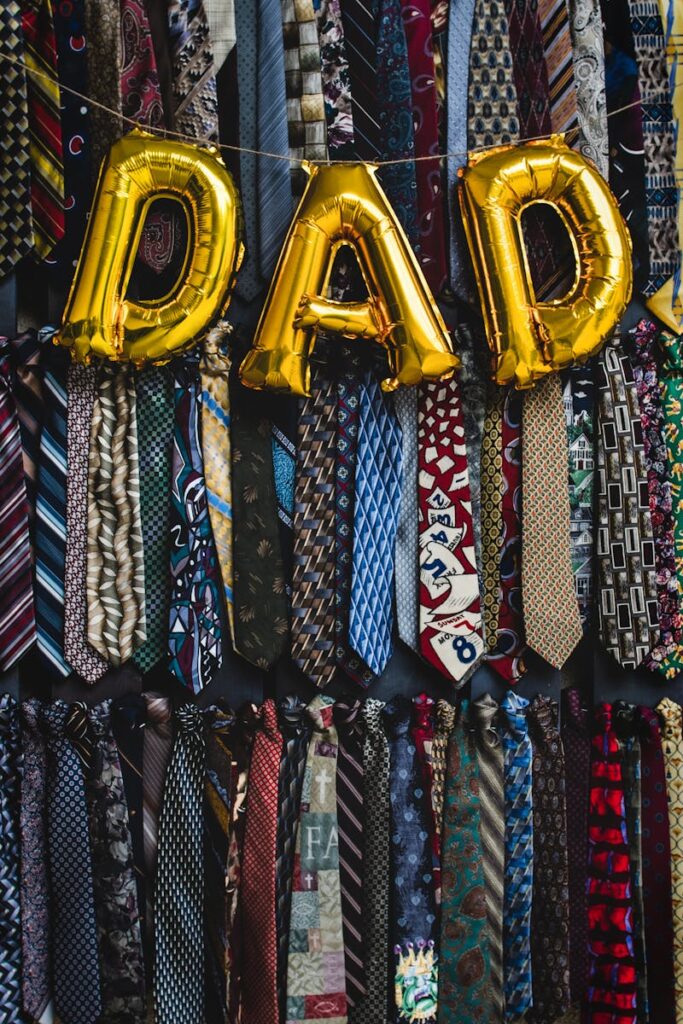 Colorful neckties with golden 'Dad' balloons create a warm Father's Day decoration.