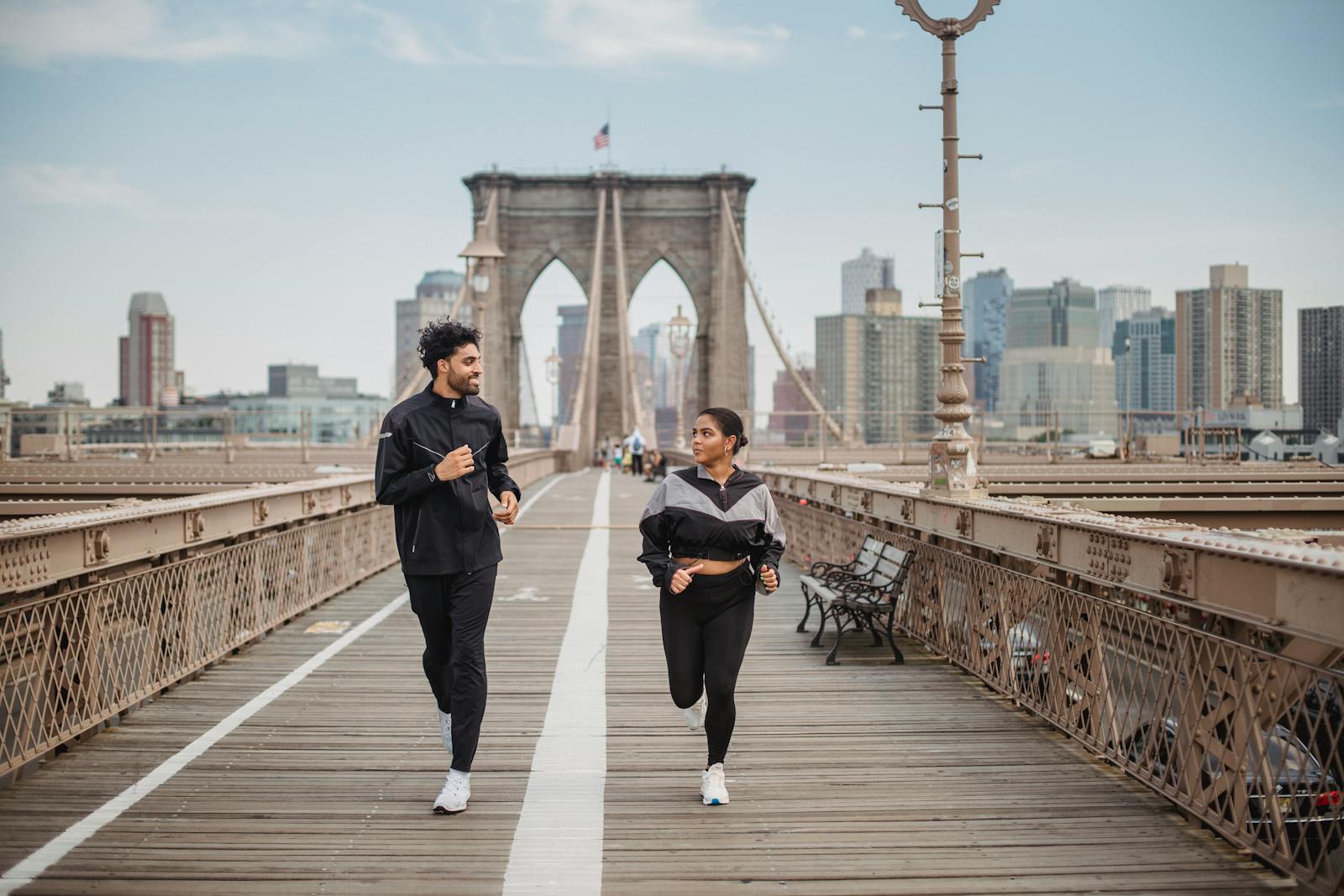 A couple jogging and enjoying fitness on the iconic Brooklyn Bridge in New York City.