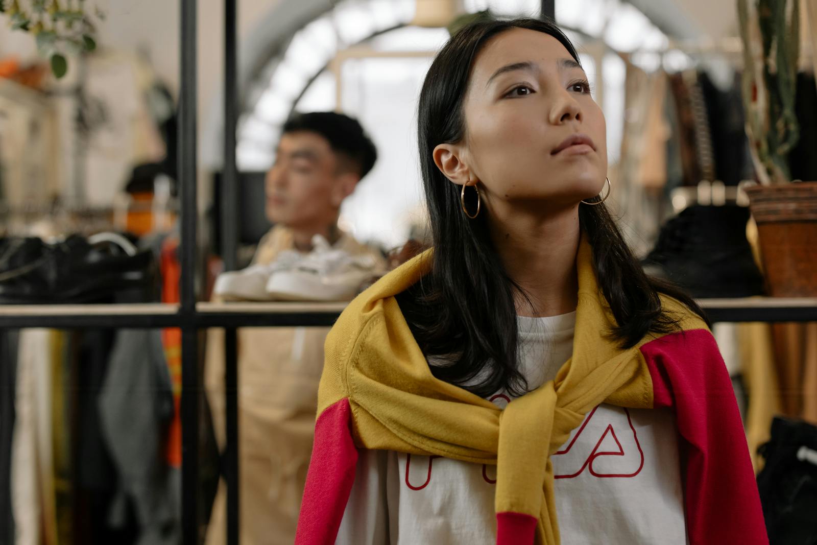 Young woman browsing a trendy clothing store, reflecting urban shopping culture.