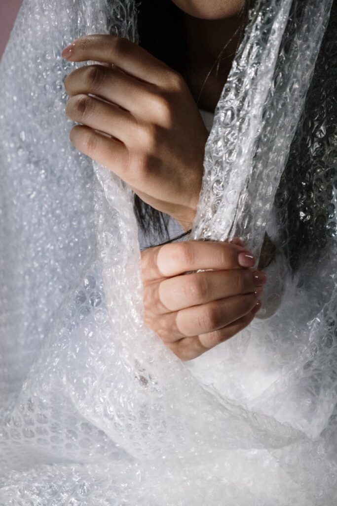 Close-up image of hands holding bubble wrap, highlighting the texture and transparency.