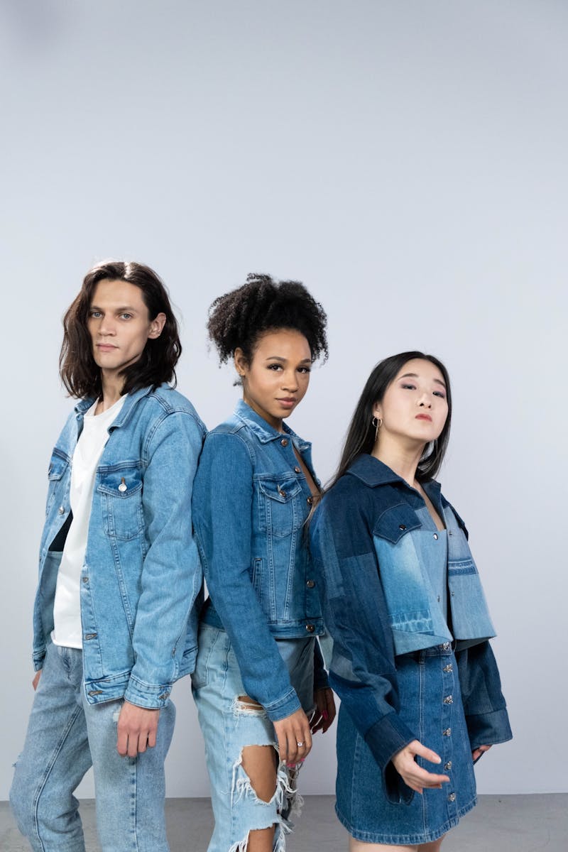 Three diverse models in trendy denim outfits posing confidently in a studio setting. Perfect for fashion and lifestyle themes.