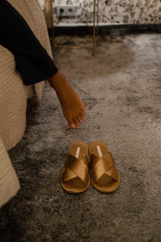 Close-up of a woman's bare feet over cozy slippers on a soft carpet in a home interior.