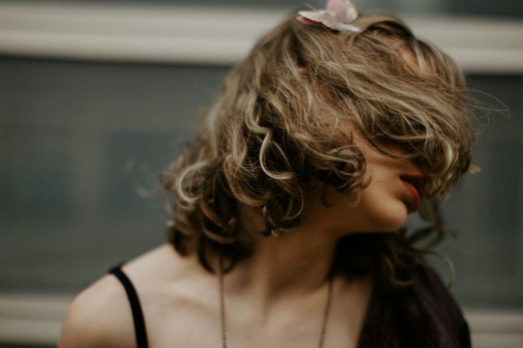 A woman with hair covering her face in motion, creating an artistic blur effect.