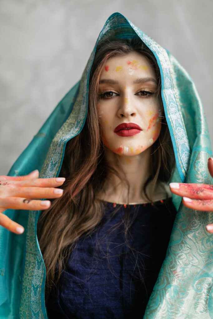A colorful portrait of a woman celebrating the Holi festival, covered in vibrant powder.