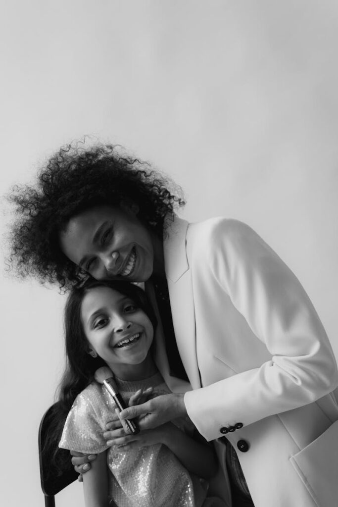 Black and white portrait of a smiling mother and daughter embracing warmly.