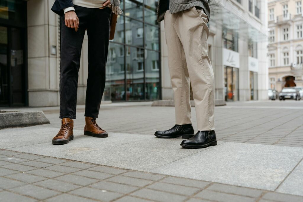 Stylish street fashion showcasing black and brown leather shoes on a city pavement.