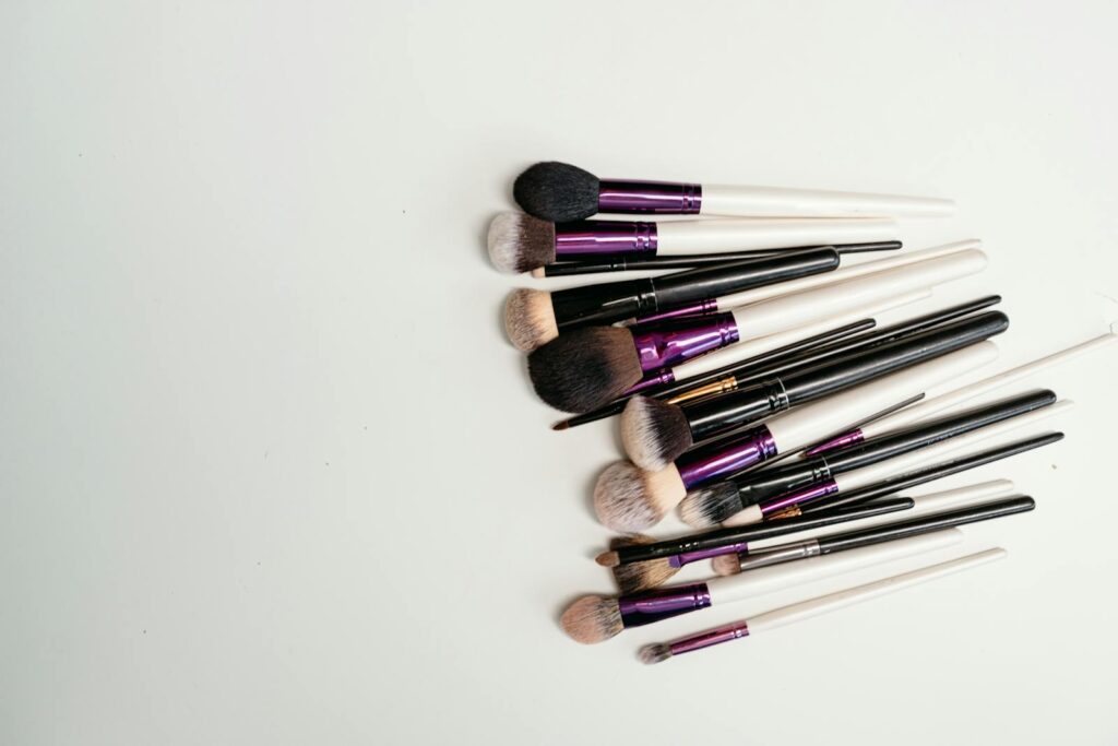 Various makeup brushes neatly arranged on a white surface for beauty enthusiasts.
