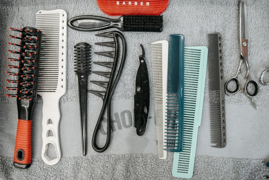 Flat lay of barber tools including combs, brushes, and scissors neatly arranged.