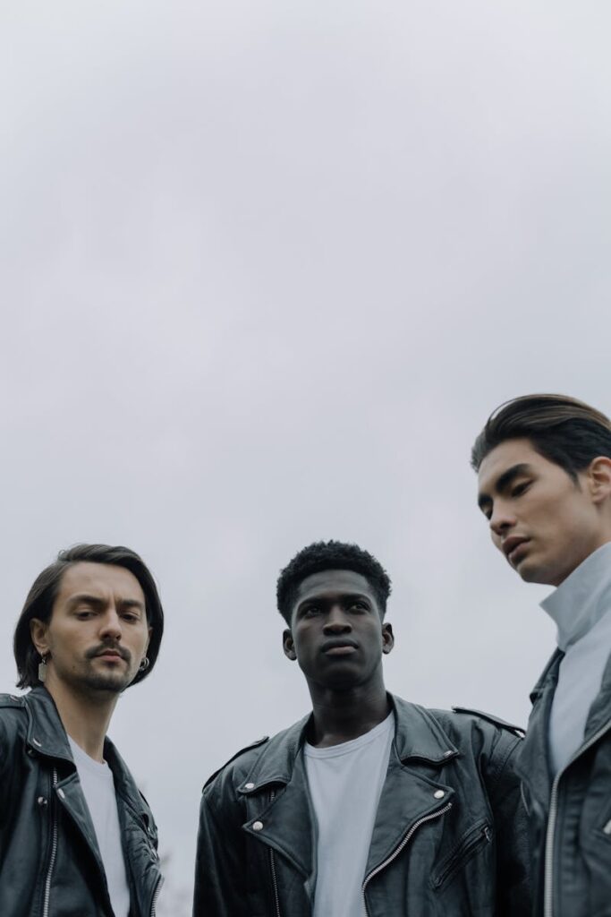 Portrait of three diverse men in leather jackets, embodying modern fashion flair outdoors.