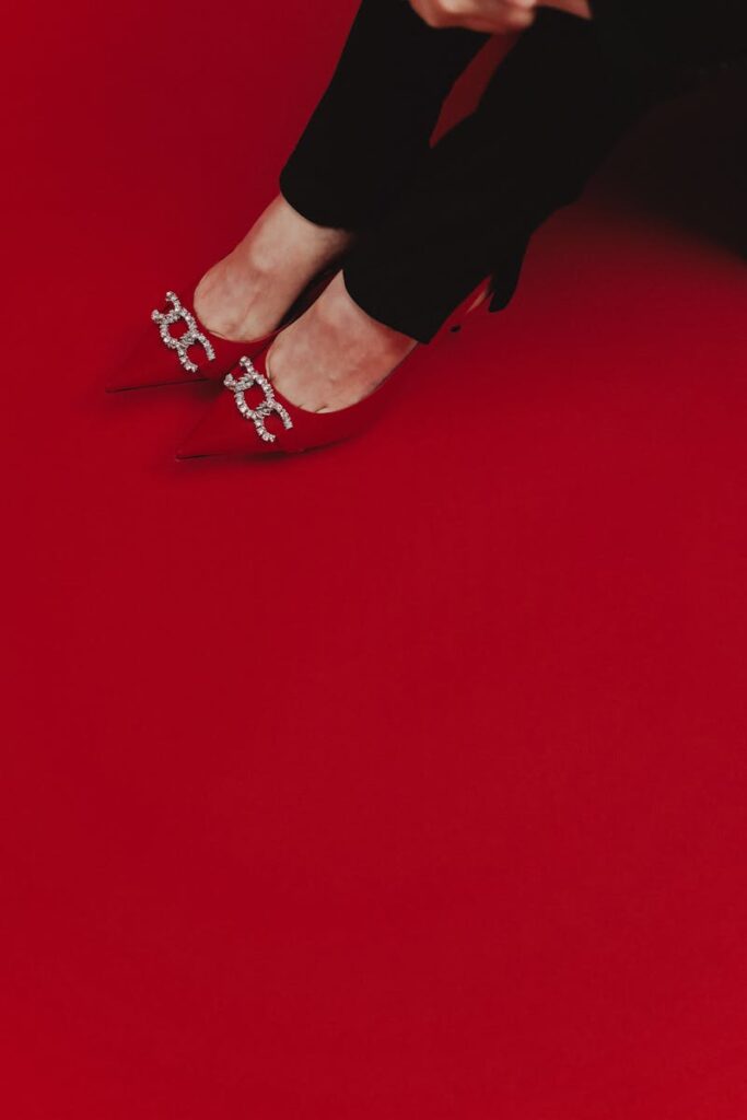 Stylish red high heels on a bold red backdrop, showcasing elegance and luxury.
