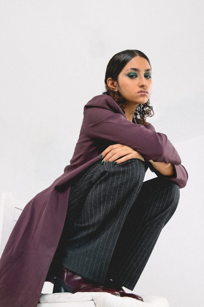 Stylish woman in a fashionable pose, showcasing modern attire in a studio setting.