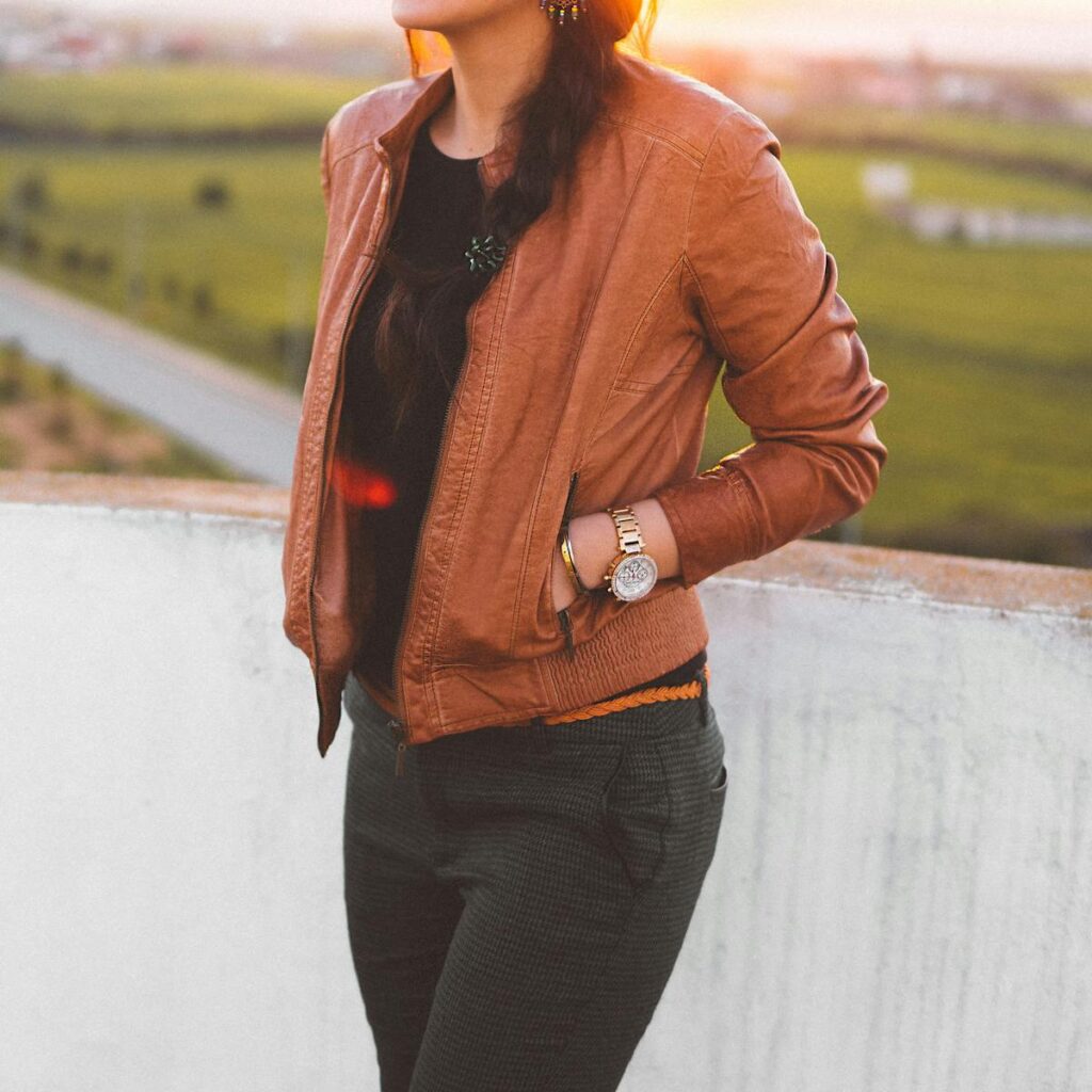 A woman in a brown leather jacket on a rooftop at sunset in Rabat, Morocco.