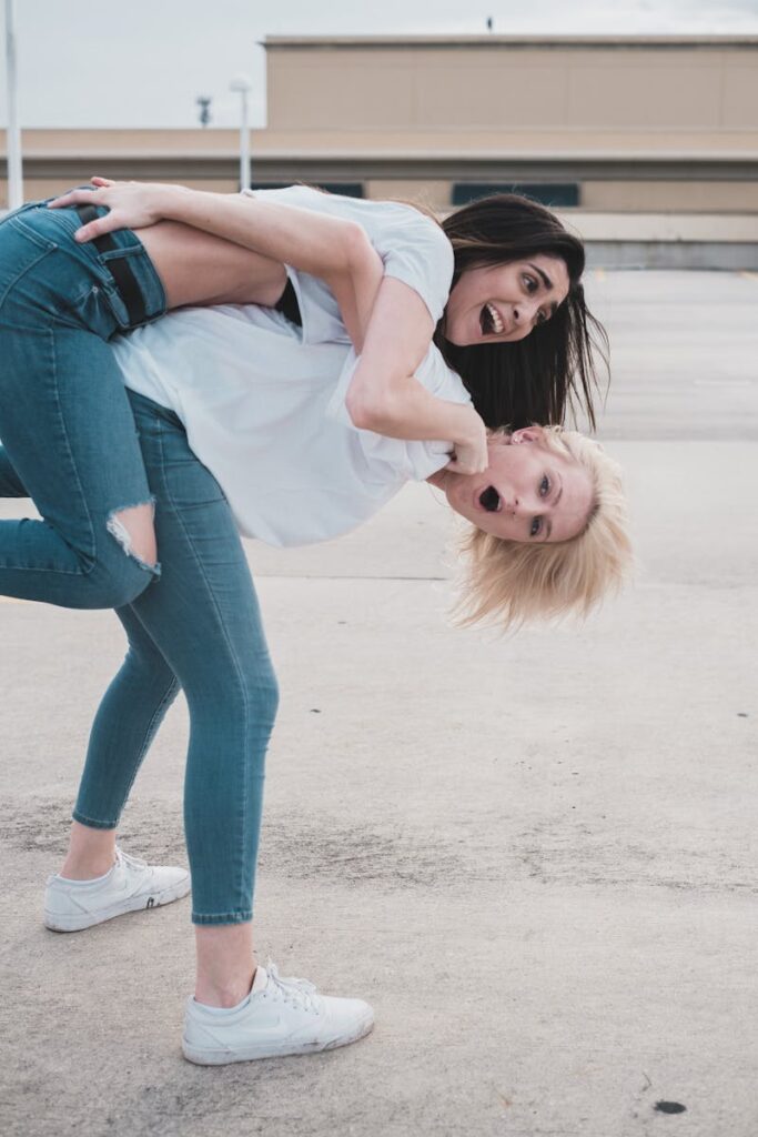 Two women enjoying a fun and playful moment with a piggyback ride outdoors.