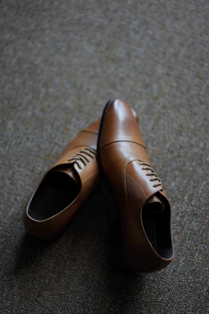 A pair of high-quality brown leather dress shoes with elegant design and classic appeal.