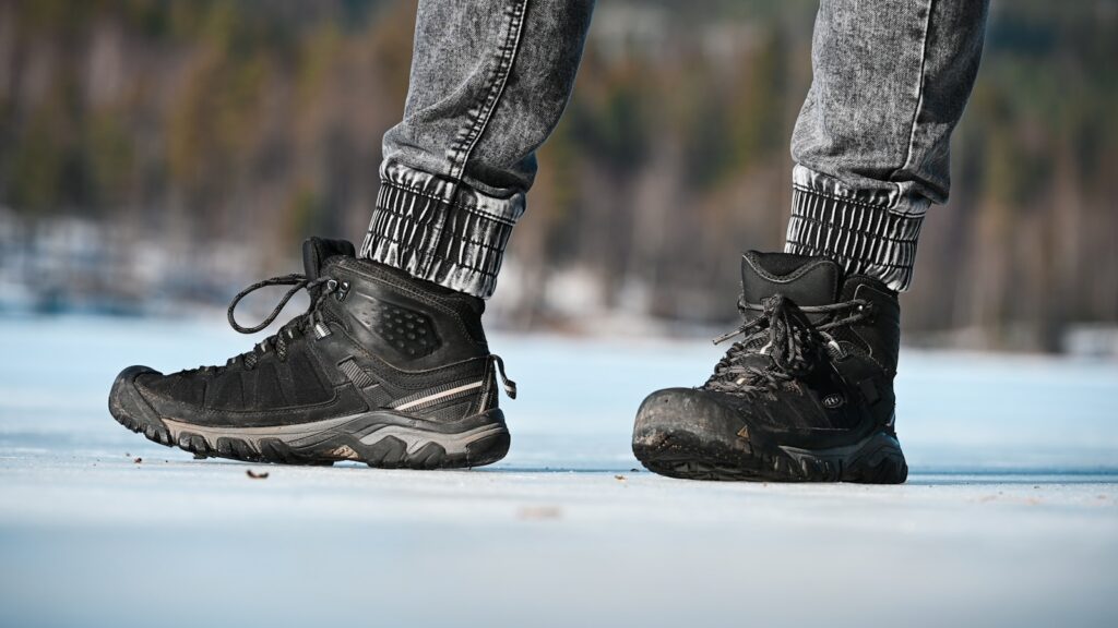 a person standing on a snowy surface wearing black shoes