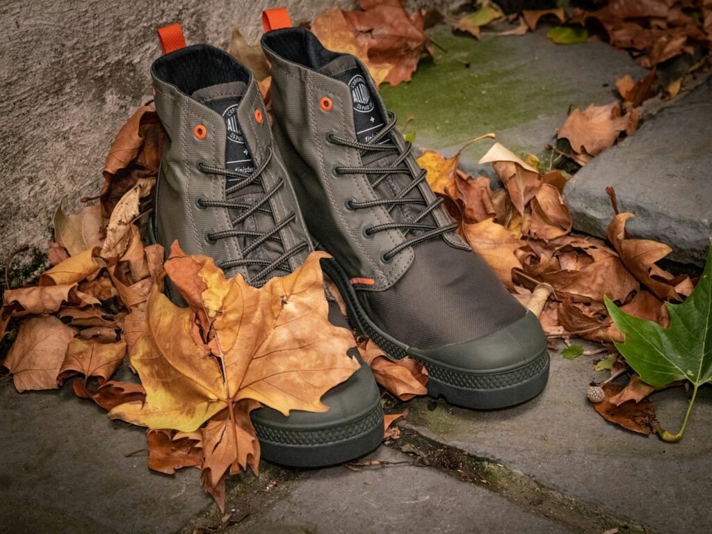 black leather boots on brown dried leaves