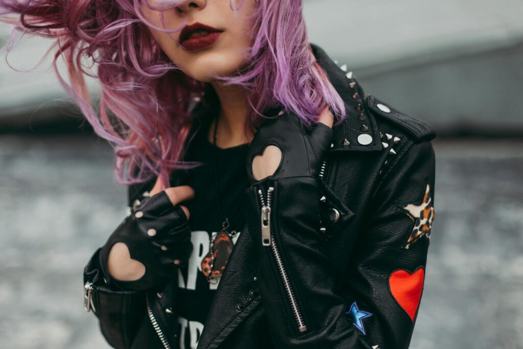 Stylish woman with purple hair in a studded leather jacket. Edgy and modern fashion.