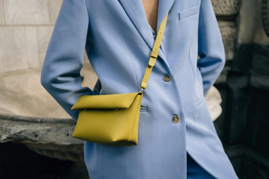 Fashion-forward outfit featuring a blue blazer and a striking yellow sling bag. Modern and chic.