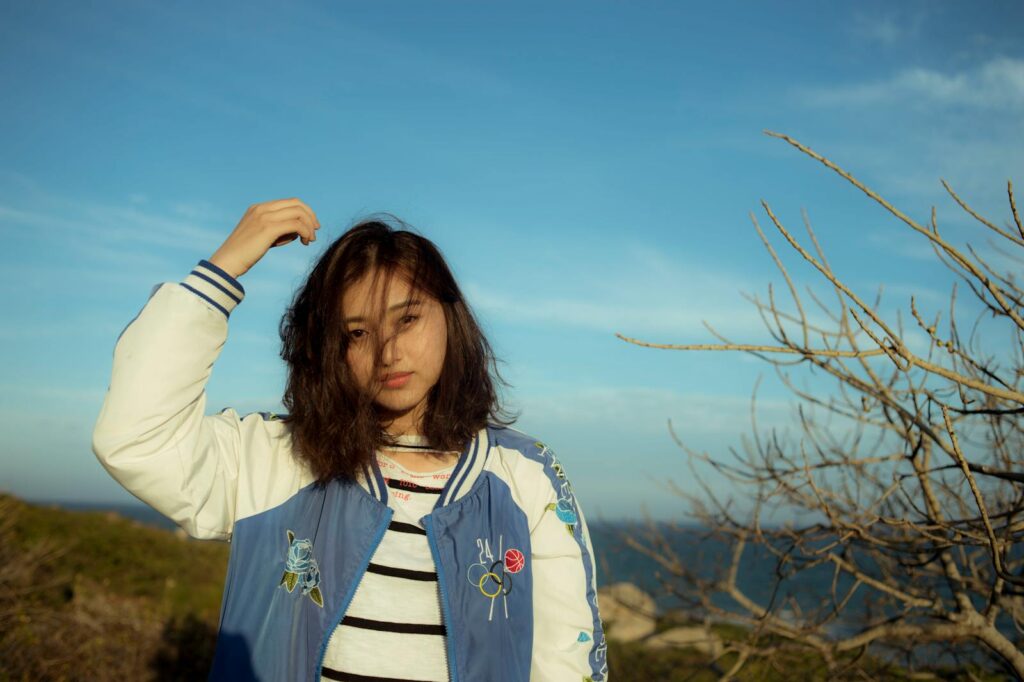 Portrait of a young woman enjoying the outdoors in Đắk Ya, Gia Lai, Vietnam under a clear blue sky.