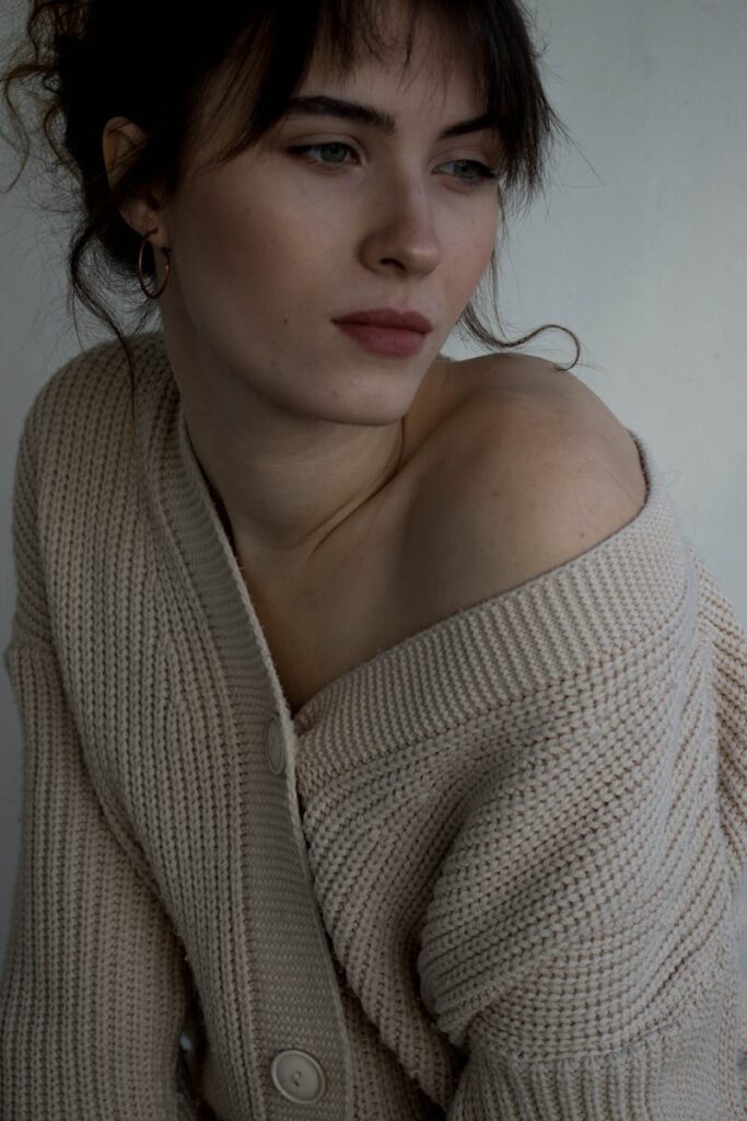 Intimate close-up of a woman in a cream cardigan, evoking a serene and contemplative mood.
