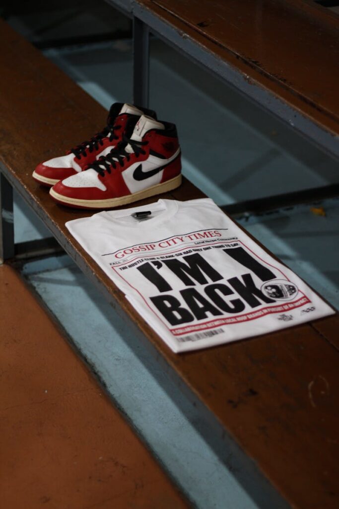 Nike sneakers and 'I'm Back' T-shirt placed on a sports bench signify fashion and sports style.