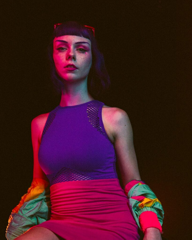 Vibrant portrait of a stylish woman in neon light, showcasing trendy fashion and bold style.