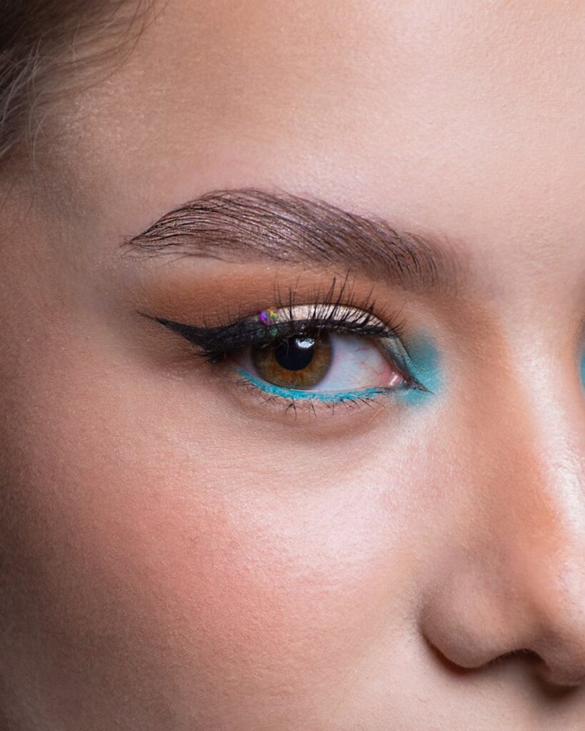 Stunning close-up of vibrant eye makeup showcasing an eyebrow with colorful eyeshadow for a bold look.