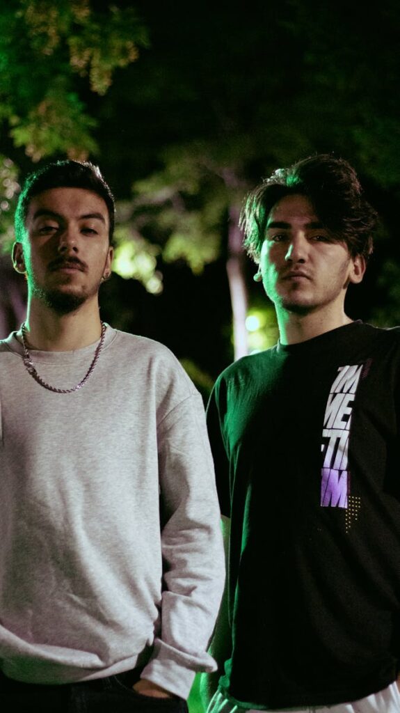 Portrait of two men standing outdoors at night in casual t-shirts in Pursaklar, Ankara.