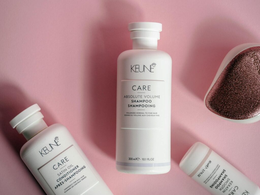 Stylish display of Keune hair care products on a pink background, emphasizing elegance and luxury.