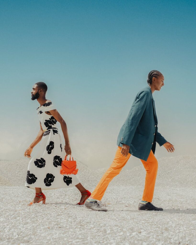 Two models showcasing bold fashion against a minimalist desert backdrop.