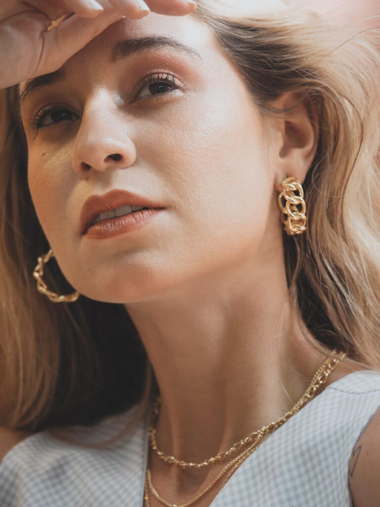 Close-up portrait of a woman with gold jewelry, capturing elegance and style.