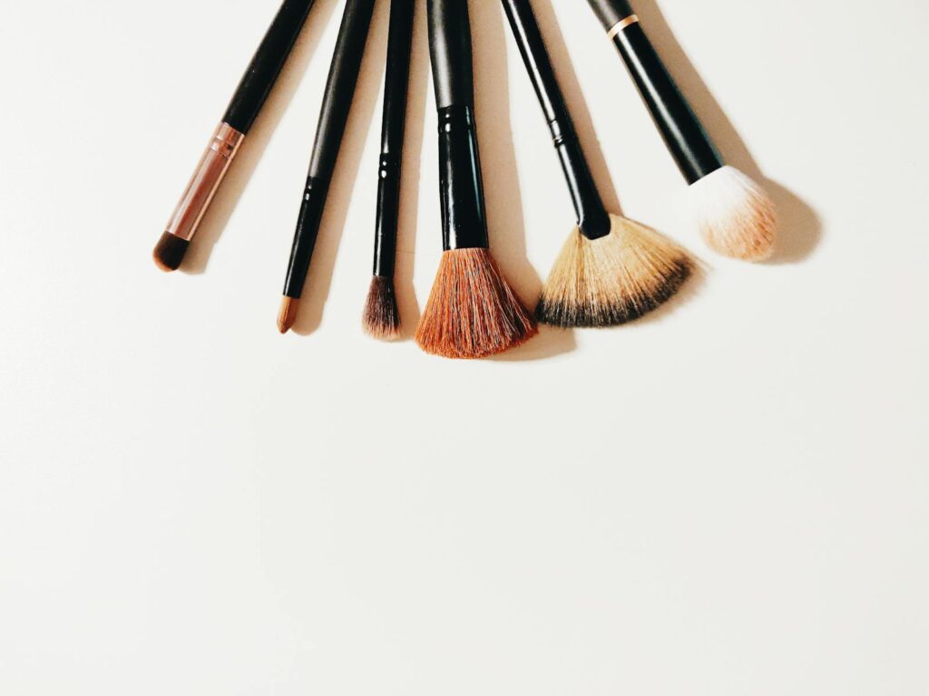 A set of makeup brushes arranged on a white surface, perfect for beauty and cosmetic themes.