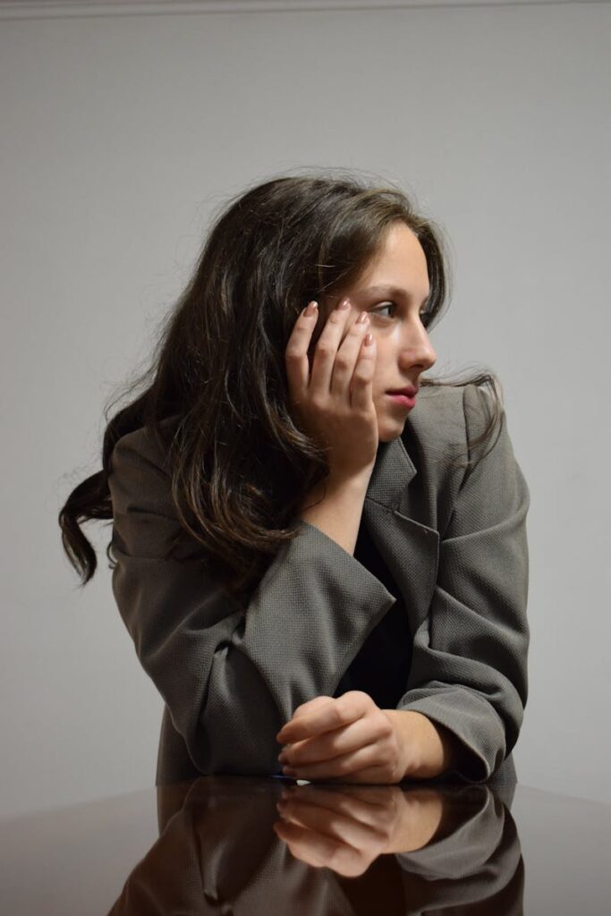 Portrait of a woman in a gray blazer, deep in thought.