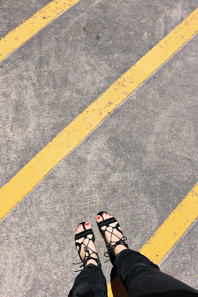 Fashionable footwear on yellow-striped pavement, highlighting style and modern design.