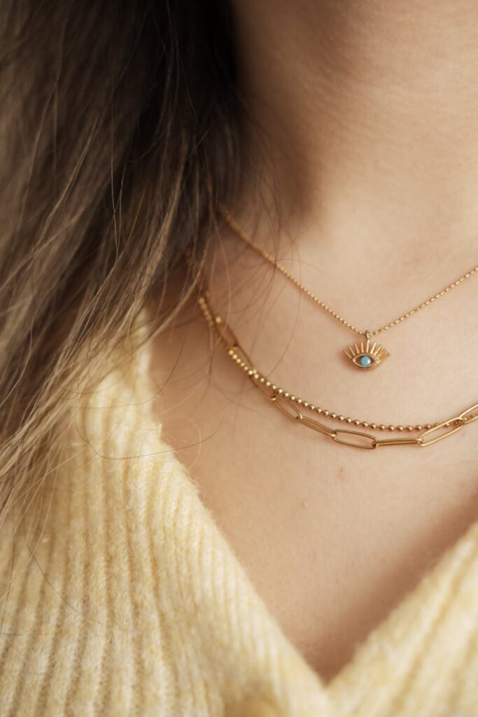 Close-up of two exquisite gold necklaces adorning the neck, showcasing luxury and elegance.
