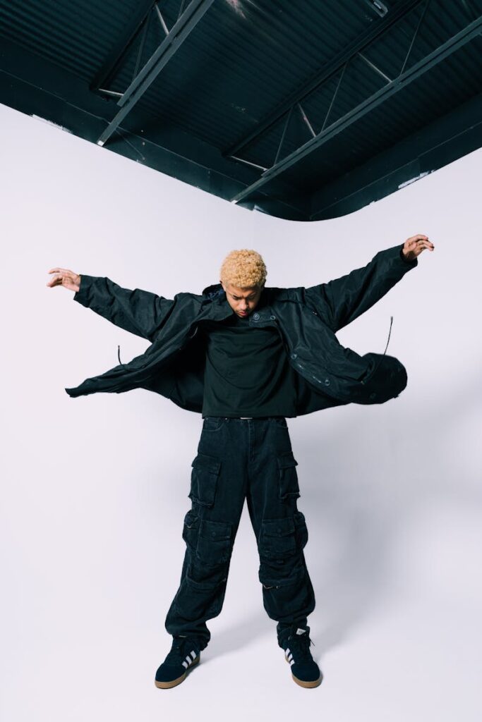 Dynamic studio shot of a man in trendy streetwear and cargo pants striking a pose.