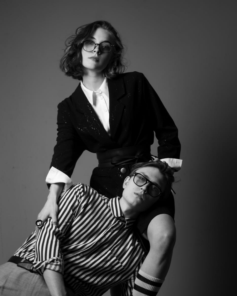 Black and white portrait of a fashionable couple in a studio setting.