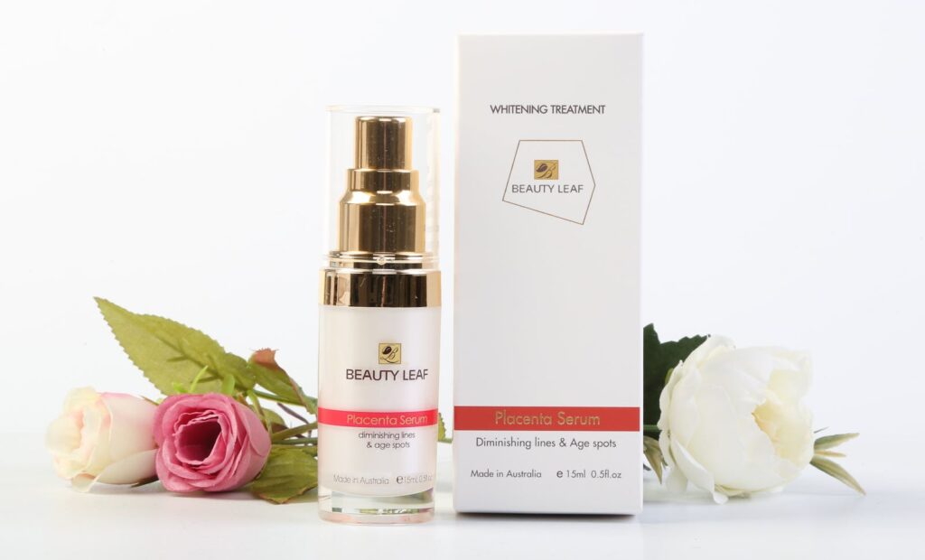Elegantly arranged Beauty Leaf serum and box with roses on a crisp white backdrop.